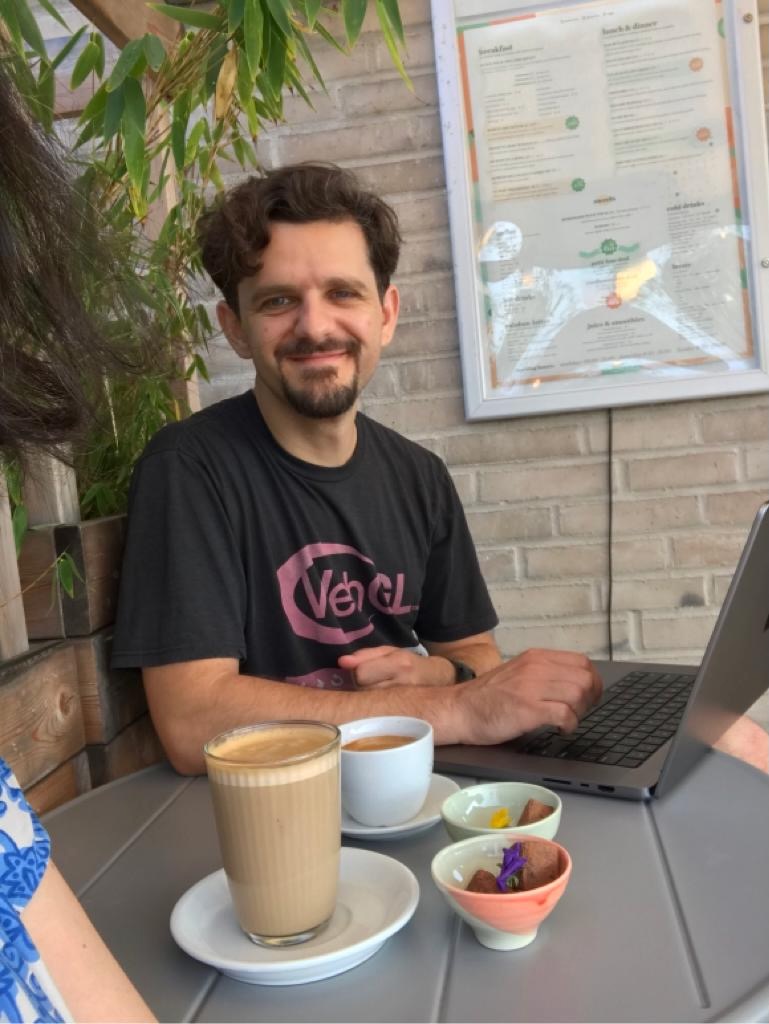 Mihai Popescu seated at a café with a laptop